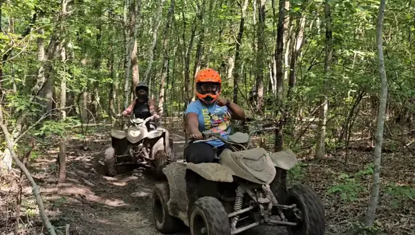 ATV riders on a tree-lined trail at NJ ATV Rentals