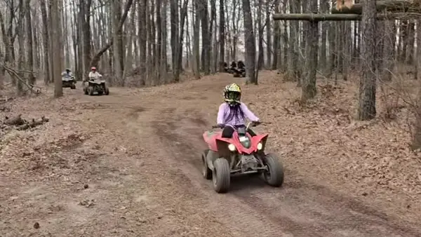ATV riders on a tree-lined trail at NJ ATV Rentals
