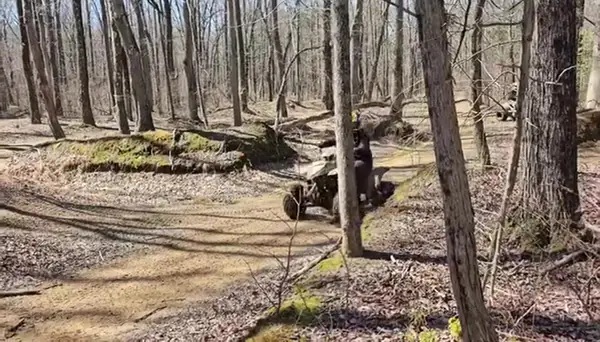 ATV riders on a tree-lined trail at NJ ATV Rentals